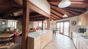 A spacious kitchen with wooden cabinets, a marble countertop, and a large island. - Beautiful compound, 10 mile views, on 300 acre ranch, next to Galena Territory (Elizabeth)