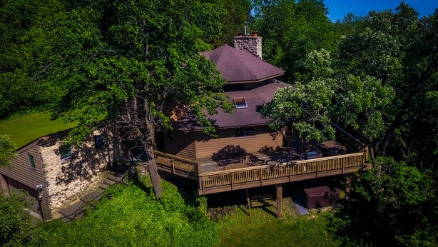 A two-story house with a deck, surrounded by dense trees. - Beautiful compound, 10 mile views, on 300 acre ranch, next to Galena Territory (Elizabeth)