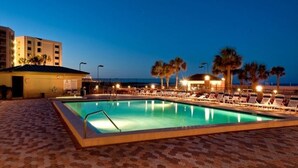 A pool area with lounge chairs and palm trees, surrounded by buildings. - PARADISE + Incredible Views! Platinum Plus Escape – Islander 514 (Destin)