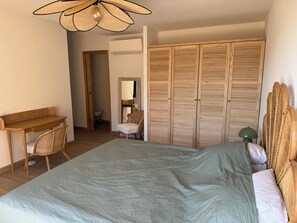 A bedroom with a bed, a desk, a chair, a wardrobe, and a ceiling fan. - Villa breathtaking sea view with pool, 550m from the beach, for 14 people (Serra-Di-Ferro)