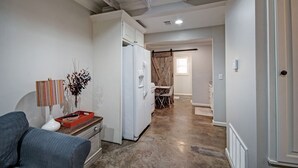 A compact kitchen with a refrigerator, a dining table with chairs, and a sofa. - Charming One-Bedroom Unit in Historic Belhaven! (Jackson)