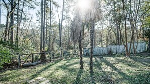 A forested area with a wooden fence and a stone pathway. - Charming One-Bedroom Unit in Historic Belhaven! (Jackson)