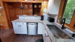 A compact kitchen with granite countertops, stainless steel appliances, and wooden cabinetry. - Peace and quiet on the lake (Becket)