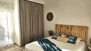 A bedroom with a wooden headboard, a bed with white bedding, and two pillows with text.