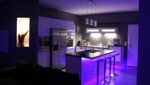 A modern kitchen with a central island, built-in appliances, and pendant lighting.