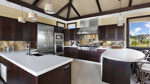 Una cocina moderna con armarios de madera oscura, electrodomésticos de acero inoxidable y una isla grande con asientos.