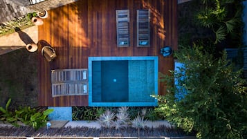 Una piscina al aire libre, sillones reclinables de piscina