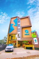 Un edificio de varios pisos con un logotipo y señalización destacados para el hotel iStay.
