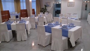 A banquet hall with tables set for a formal event, featuring white chairs and blue tablecloths. - Hotel Zovko (Sibinj)