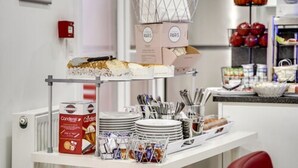 A buffet setup with various food items and condiments. - Paris hôtel (Clichy)