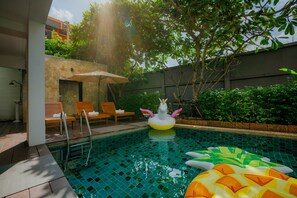 Alberca al aire libre, sombrillas en la alberca y camastros