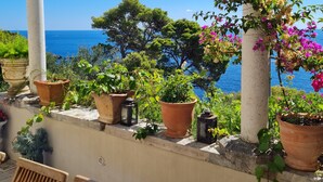 A terrace with potted plants, a table, and chairs overlooking a body of water. - 16th century villa Filomena, panoramic sea views, walking distance to Old Town (Dubrovnik)