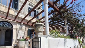 A building with a stone staircase leading to an entrance, a pergola with wooden beams, and a white wall with arched niches. - 16th century villa Filomena, panoramic sea views, walking distance to Old Town (Dubrovnik)