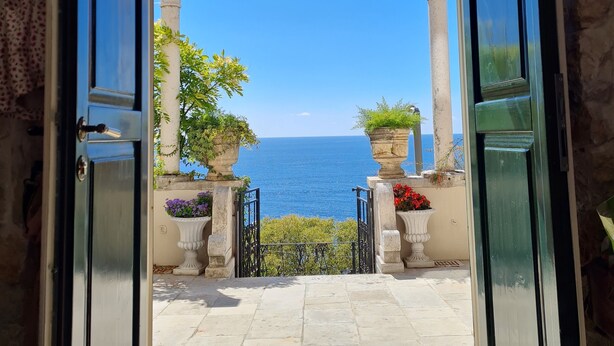 An open doorway leading to a terrace with a view of the sea, stone columns, and potted plants. - 16th century villa Filomena, panoramic sea views, walking distance to Old Town (Dubrovnik)