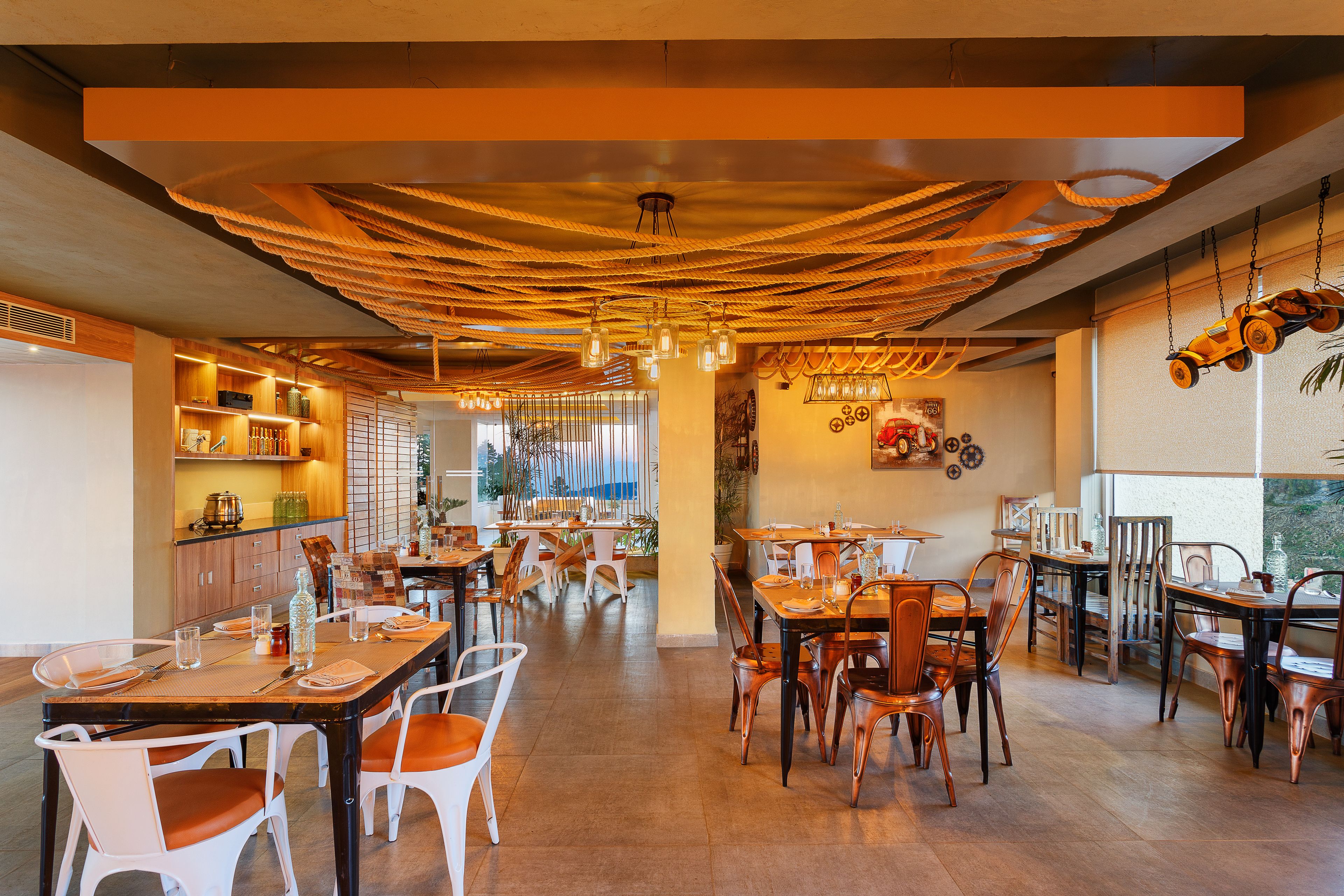 A spacious restaurant with high ceilings, exposed beams, and a variety of seating arrangements including tables and chairs.