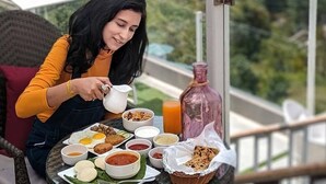 En person som njuter av en måltid utomhus med en vacker bergsutsikt i bakgrunden.