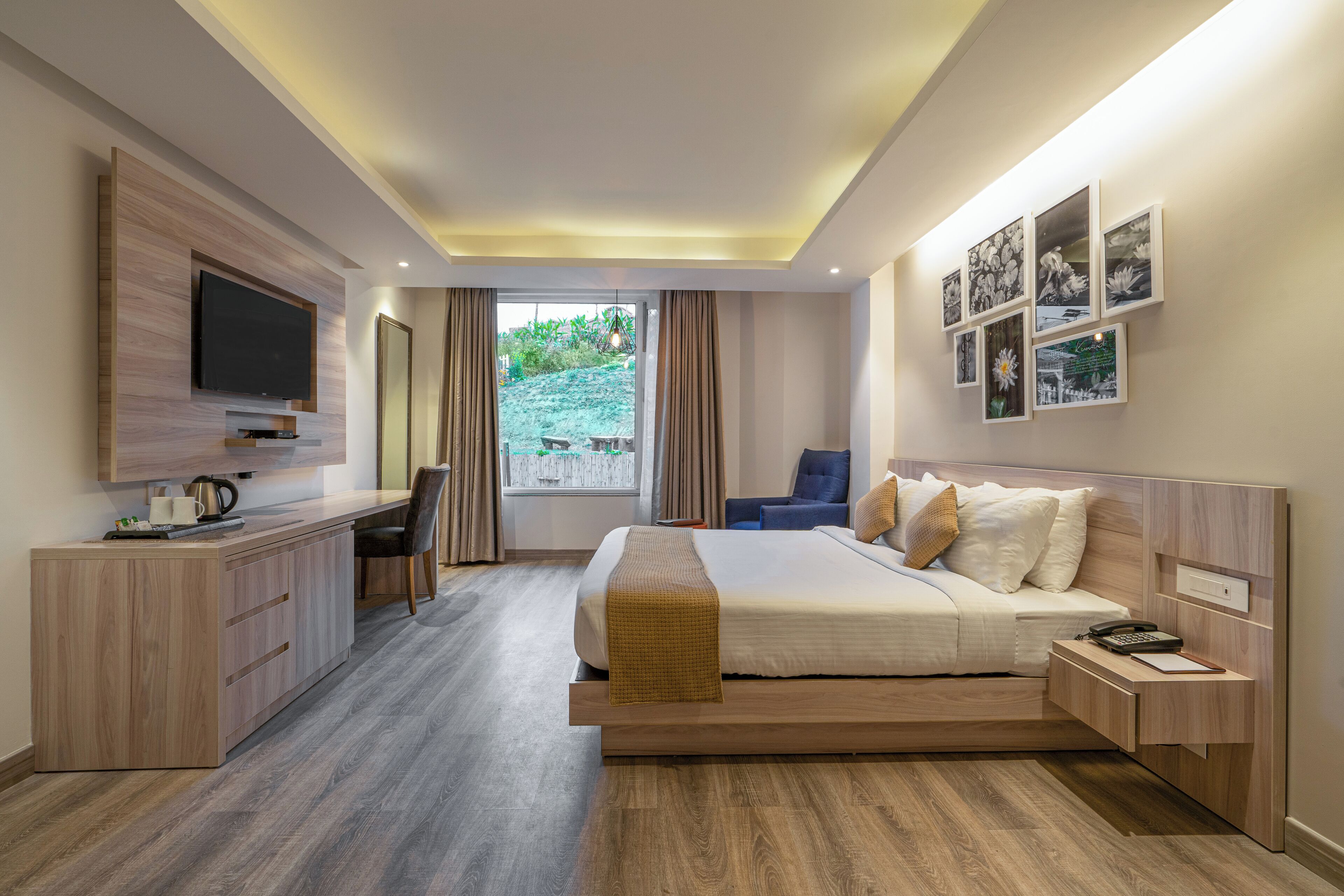 A modern hotel room with a bed, desk, and TV.