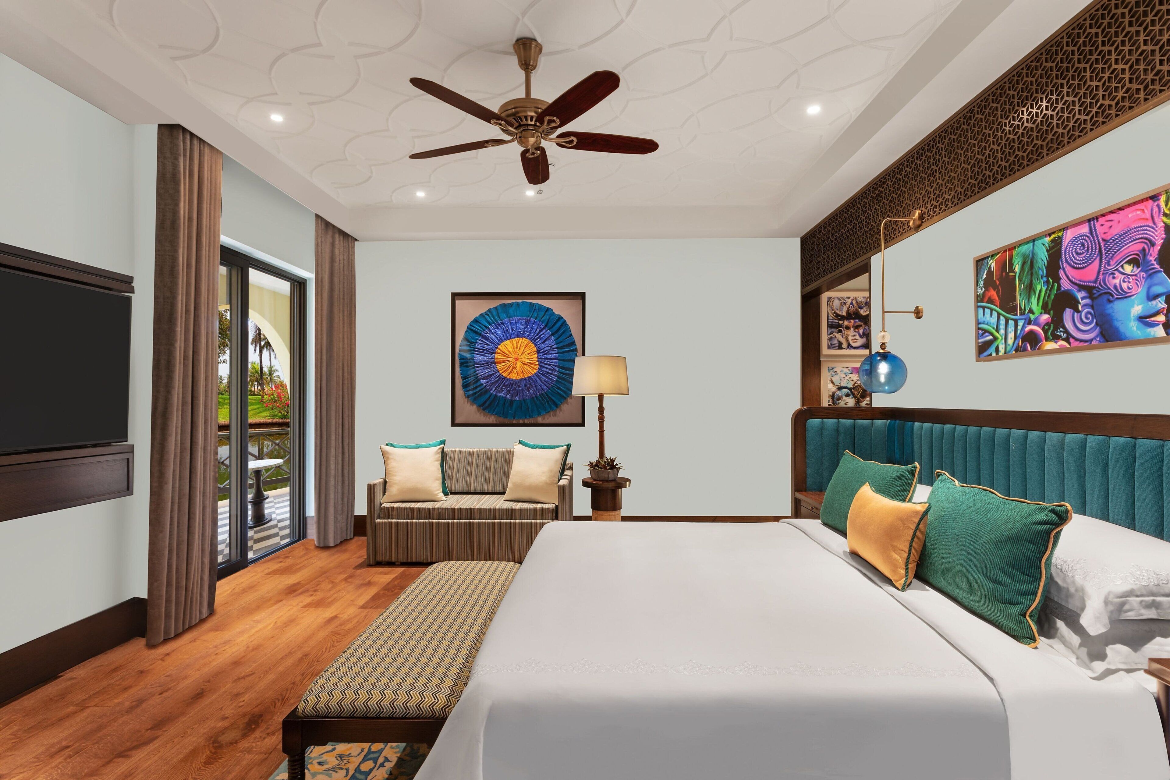 Habitación de hotel con una cama grande, ventilador de techo, televisor, ventana con cortinas, un cuadro en la pared y una planta en maceta.