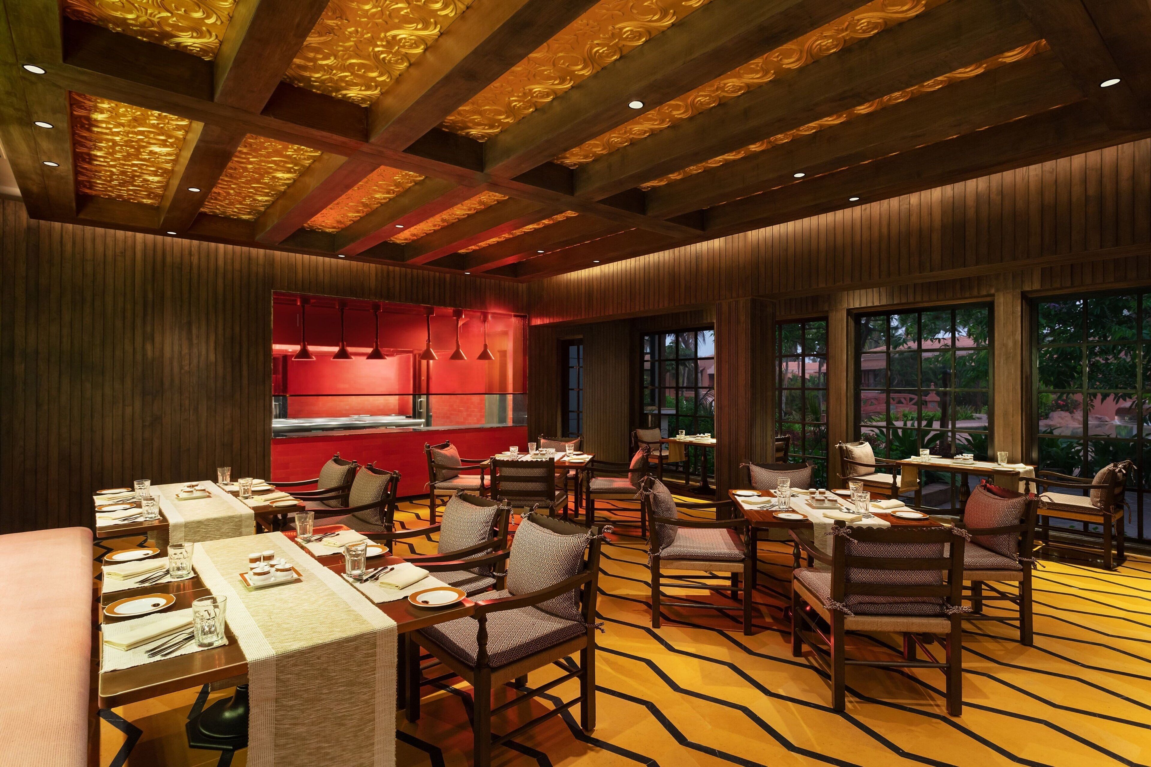 A restaurant with wooden paneling, tables set with plates and glasses, and a patterned carpet.