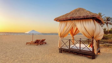 Na praia, espreguiçadeiras, guarda-sóis, toalhas de praia