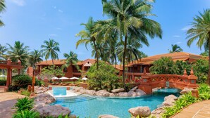 A resort with a swimming pool, palm trees, and a bridge. - ITC Grand Goa, a Luxury Collection Resort & Spa, Goa (Cansaulim)