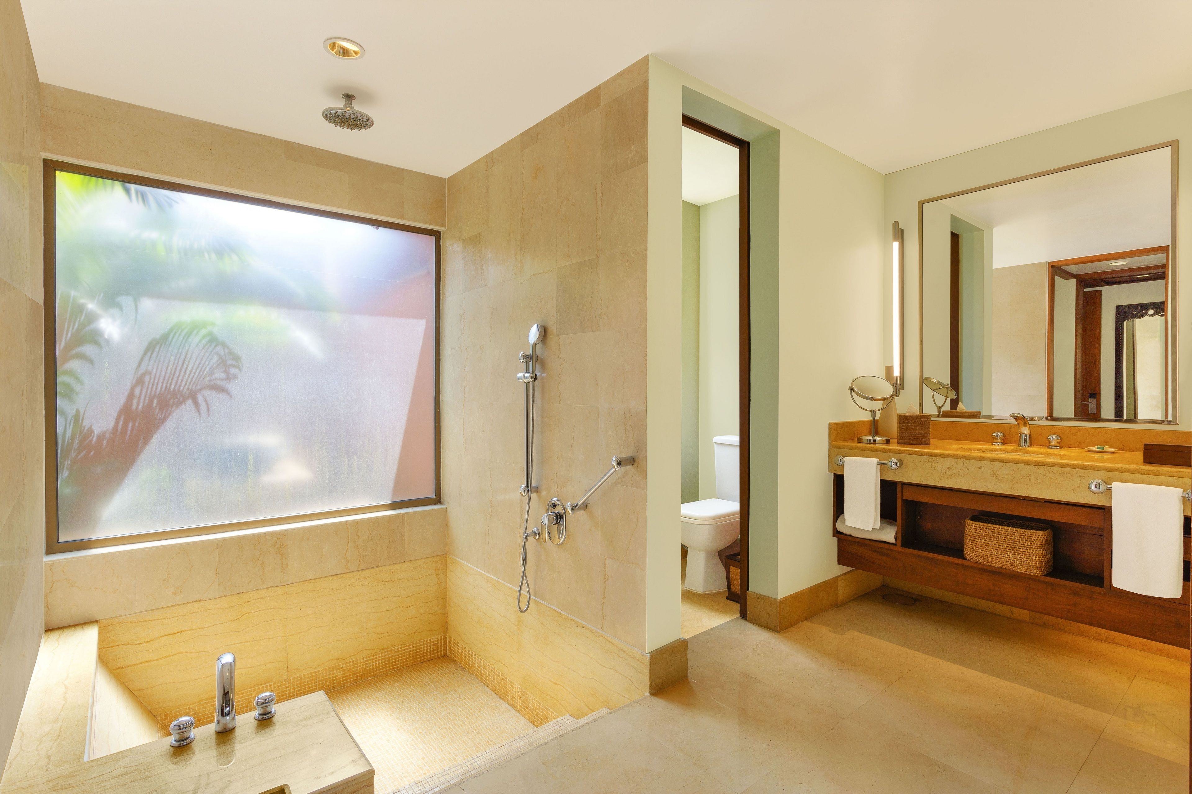 Un baño moderno con un ventanal grande, una bañera, una ducha y un tocador con espejo.