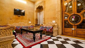 Une pièce avec deux canapés richement décorés, une petite table et un sol à carreaux.