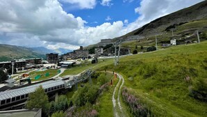 A modern building complex with multiple floors, a covered walkway, and a ski lift.