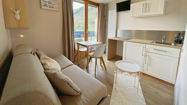 A modern apartment with a living room, dining area, and kitchen.