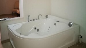 A modern bathroom with a freestanding bathtub, a small mirror, and a towel rack. - Nonna Ia (Parabita)