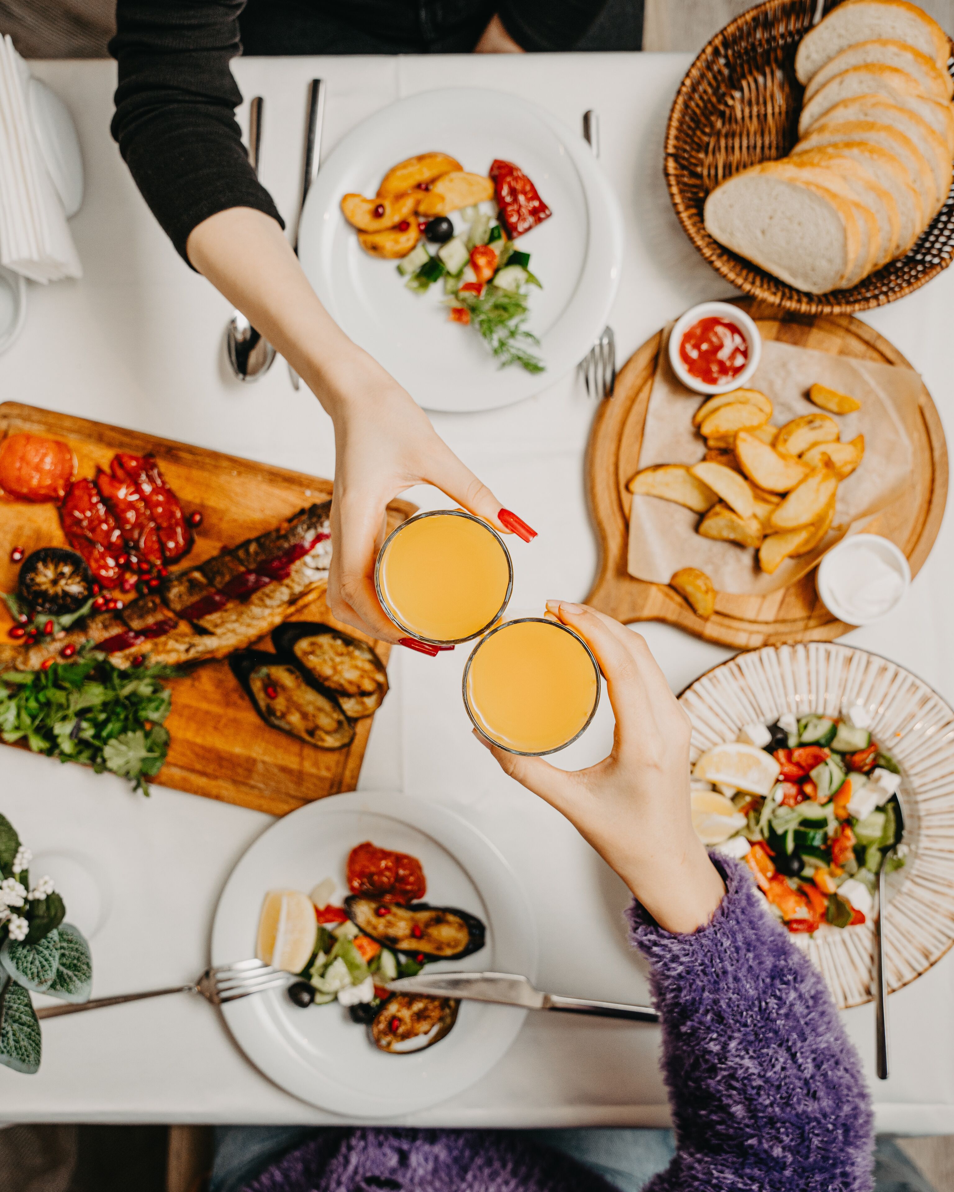 A dining table with various dishes, including grilled meat, salads, and bread.
