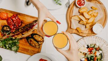 A dining table with various dishes, including grilled meat, salads, and bread.