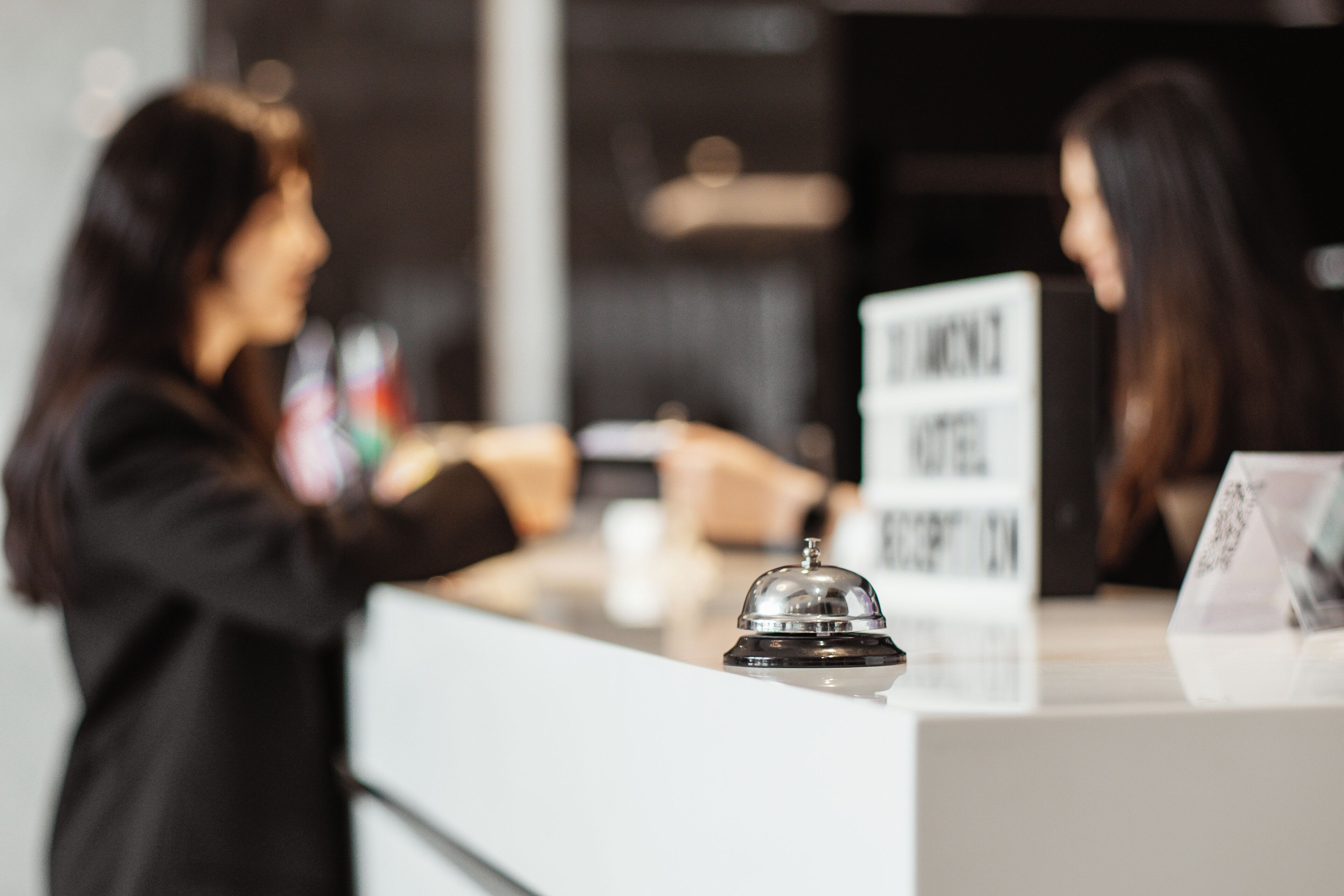 A reception desk with a bell, a sign, and a counter.