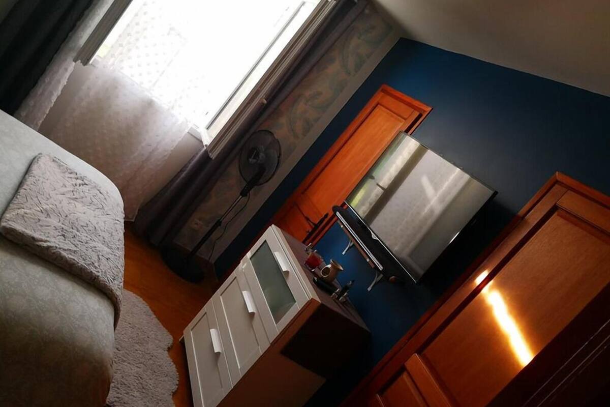 Un dormitorio con cama, cómoda, espejo y ventana.