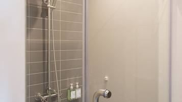 A modern shower with a handheld showerhead and a handheld faucet.