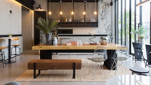 Een moderne keuken met een houten aanrechtblad, hangende hanglampen en een groot raam.