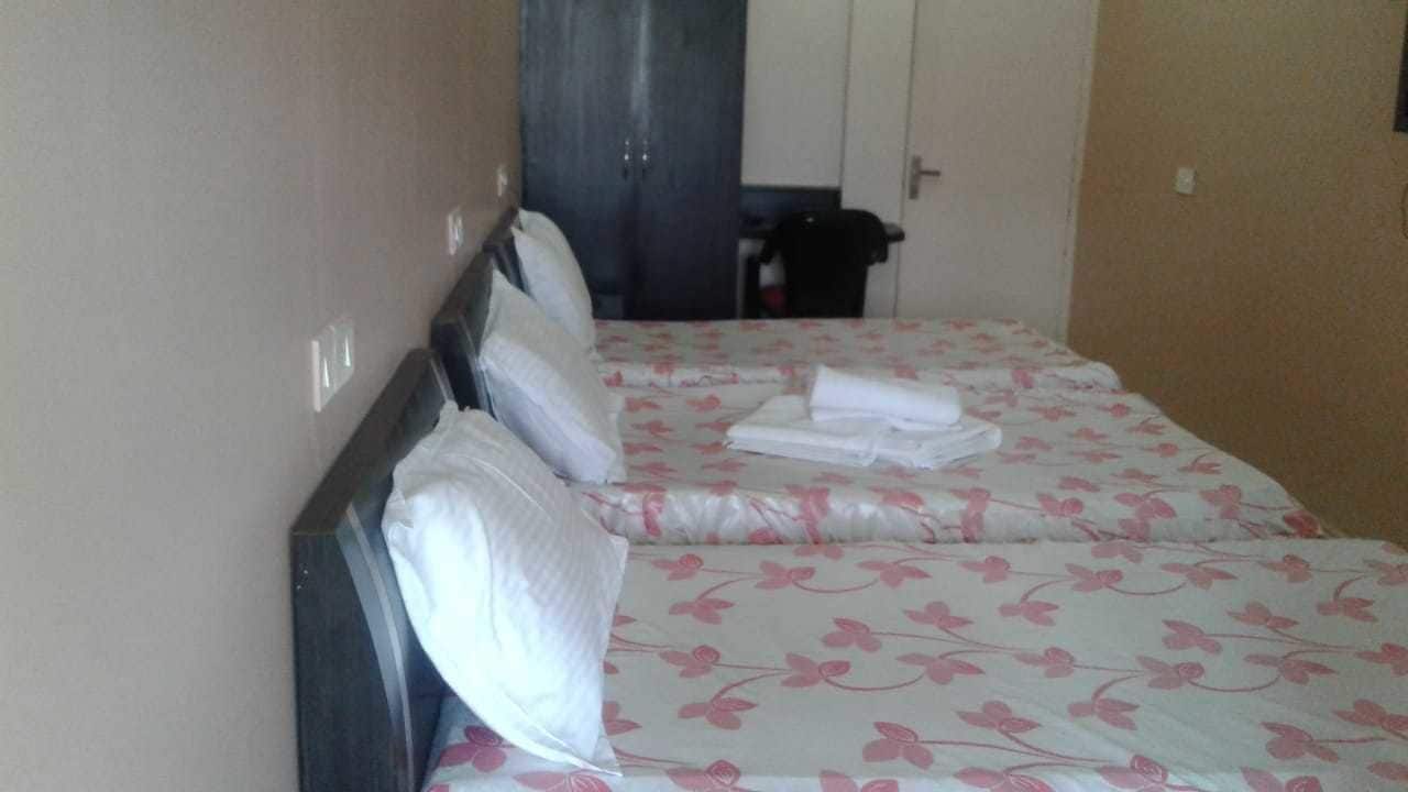 A hotel room with a bed, pillows, and a neatly folded towel.