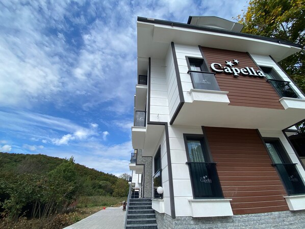 A modern building with a 'Capella' sign, featuring a multi-level structure with a staircase leading to the entrance. -  Ağva Capella Hideaway Adult Only (Sile)