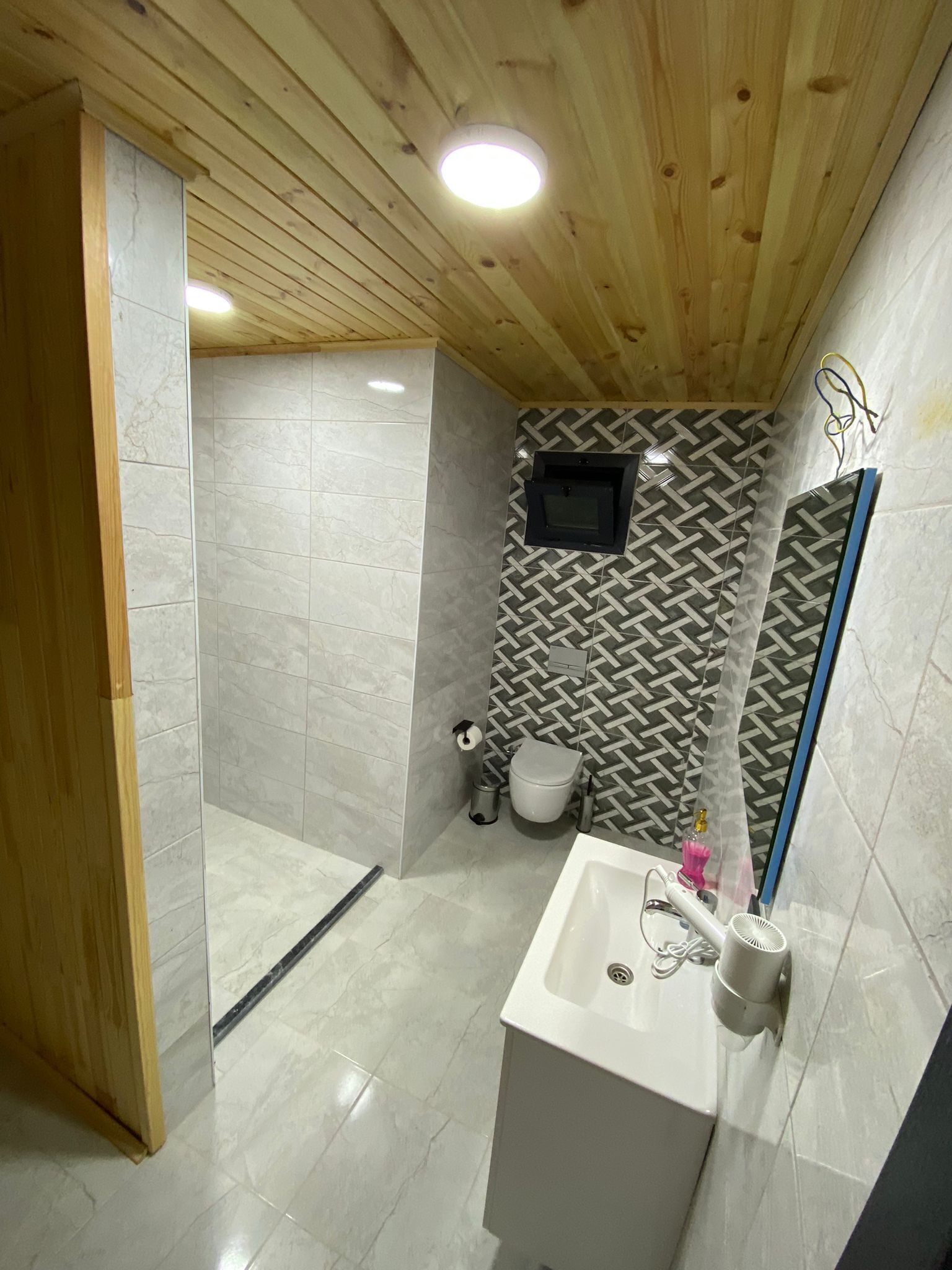 A bathroom with a shower, toilet, and sink.
