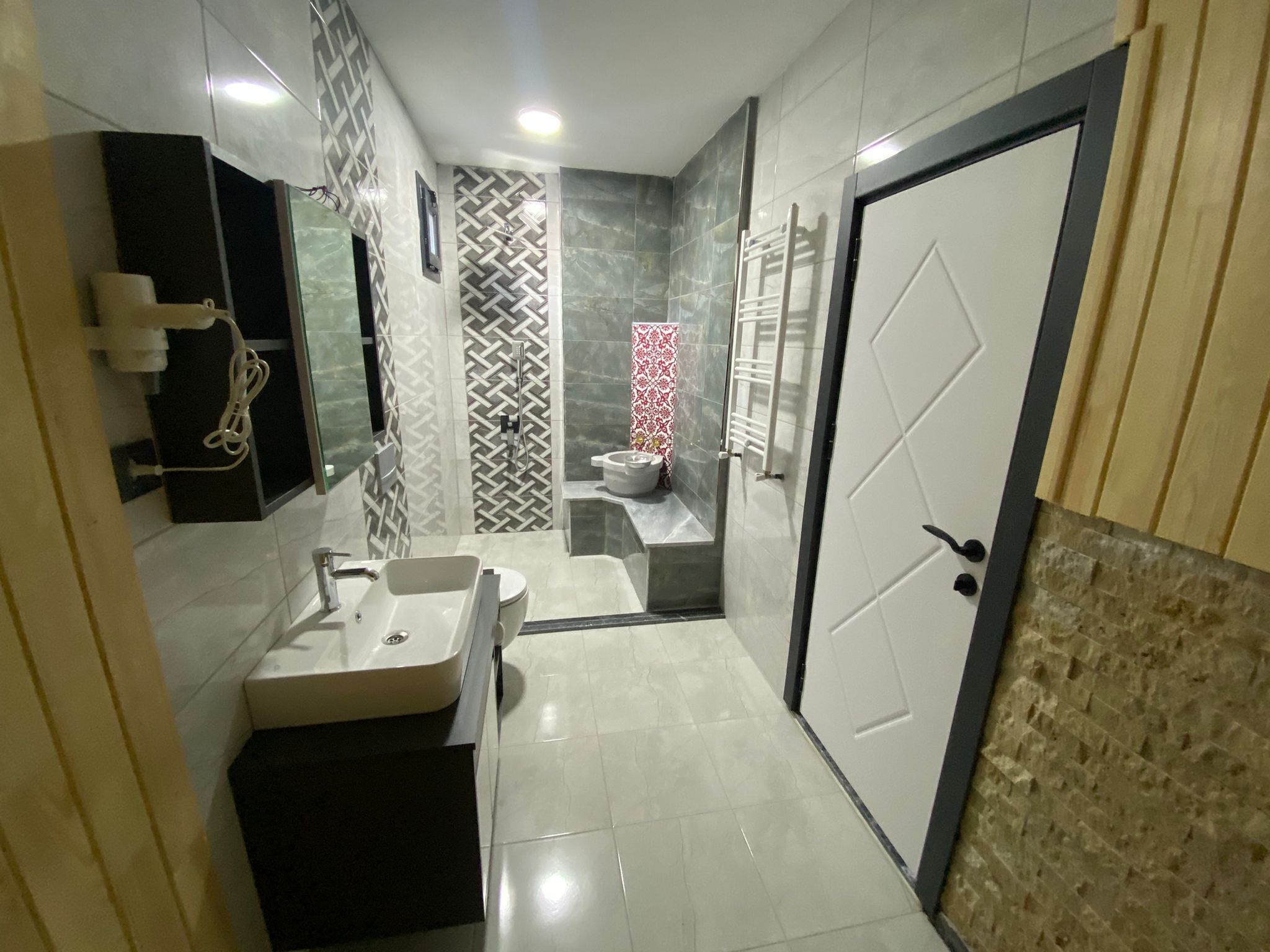 Casa de banho moderna com lavatório, sanita e zona de duche.