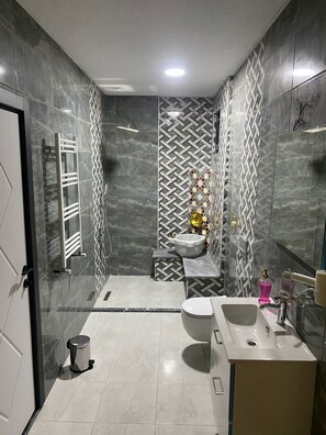 A modern bathroom with a large mirror, a sink, a toilet, and a shower area. -  Ağva Capella Hideaway Adult Only (Sile)