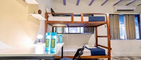 A bunk bed room with a desk, chair, and storage cabinets.