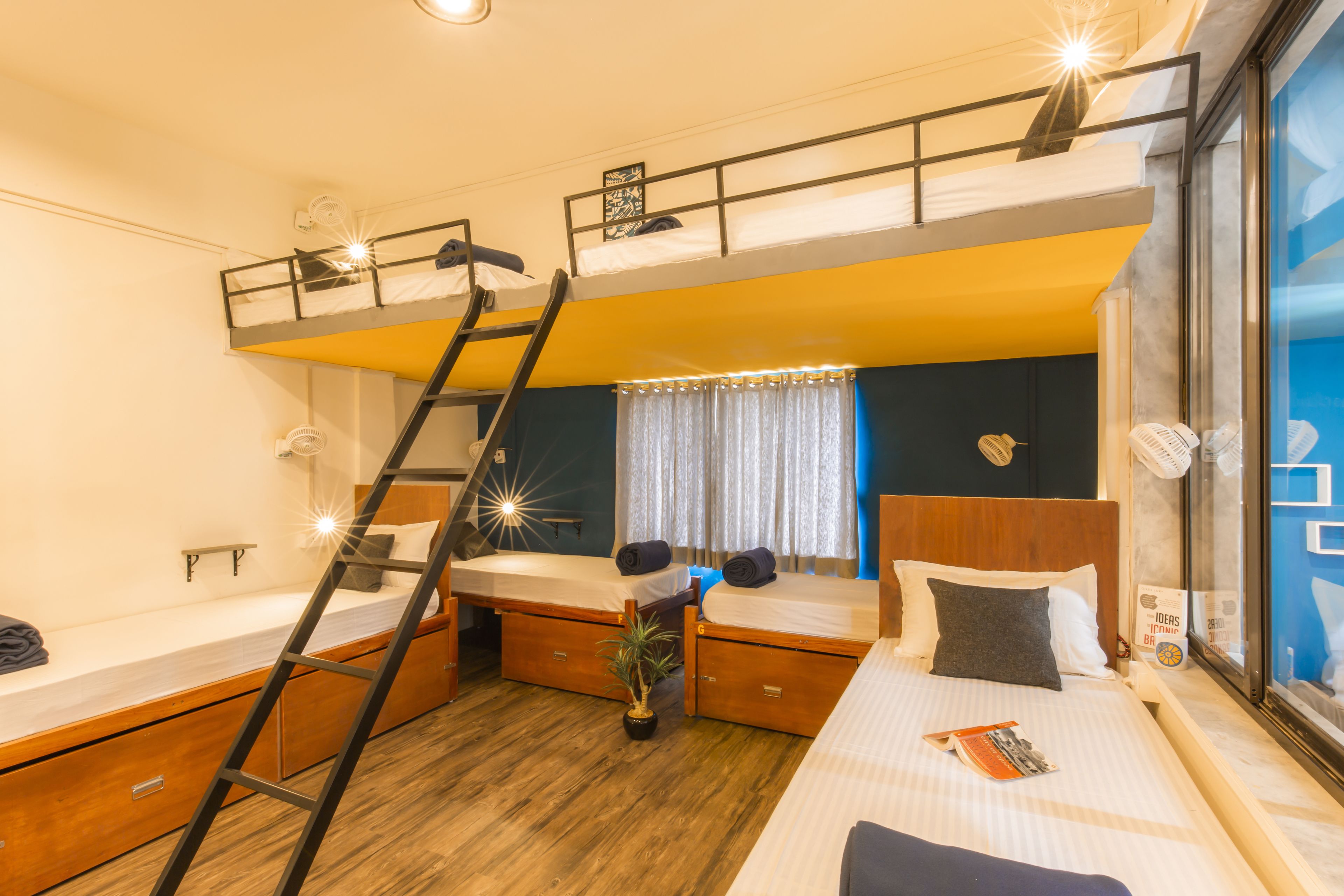 Habitación con literas, escritorio y ventana con cortinas.