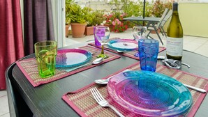 Tavola apparecchiata per la cena, con bicchieri colorati e una bottiglia di vino, con vista panoramica.
