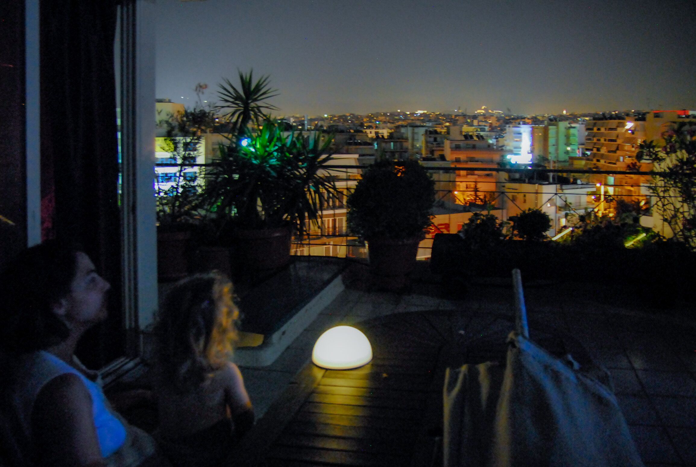 Un balcon donnant sur une vue panoramique de la ville la nuit.