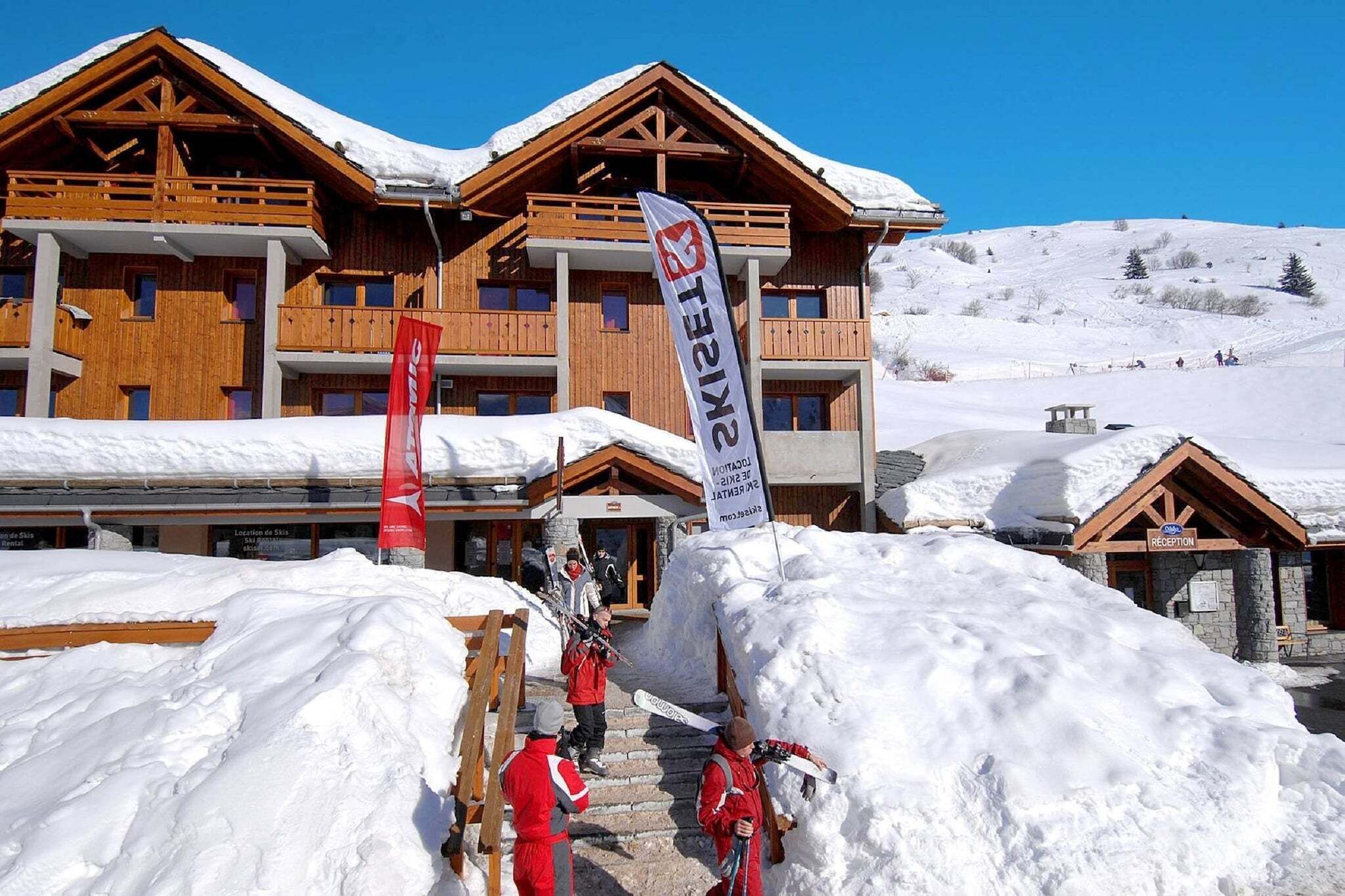 Un bâtiment d’une station de ski doté de nombreux balcons et d’un espace d’accueil.