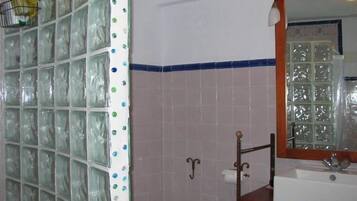 Een bad/douchecombinatie, een haardroger, een bidet, handdoeken
