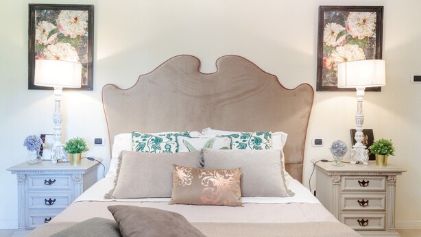 A bedroom with a large bed, two bedside tables, and two wall-mounted lamps. - Beautiful Villa Lory on the hills of Lucca (Segromigno in Monte)