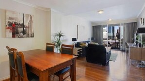 A modern apartment with a dining area, living room, and a balcony with a city view. -  Luxury 2 bedroom apartment Sydney, Darling Harbour, ICC and free secure parking (Sydney)