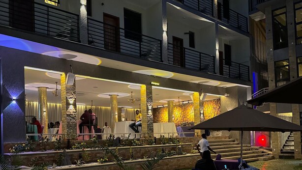 Un hotel de varios pisos con asientos al aire libre y un patio bien iluminado.